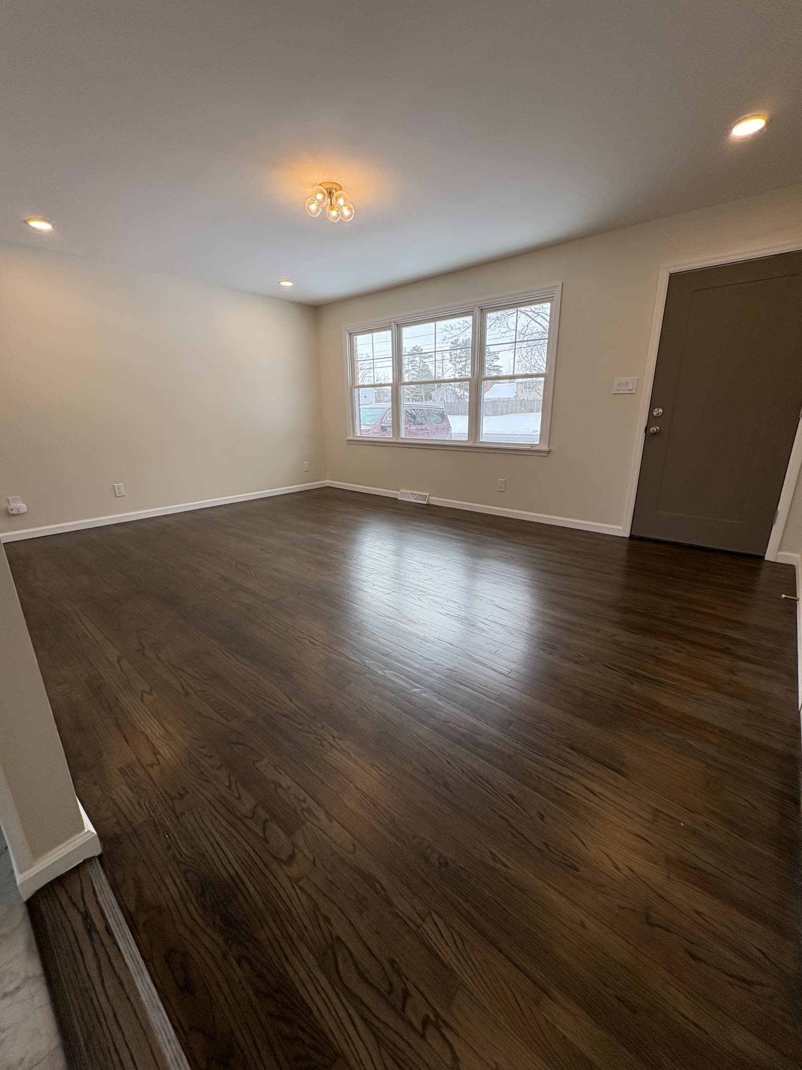 Living room after new flooring, paint, and lighting.